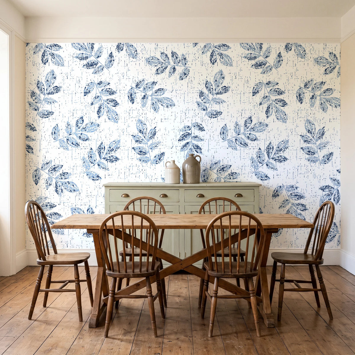 Verdant Scatter Navy tossed leaf wallpaper in a farmhouse dining room with a sage sideboard and rustic trestle table