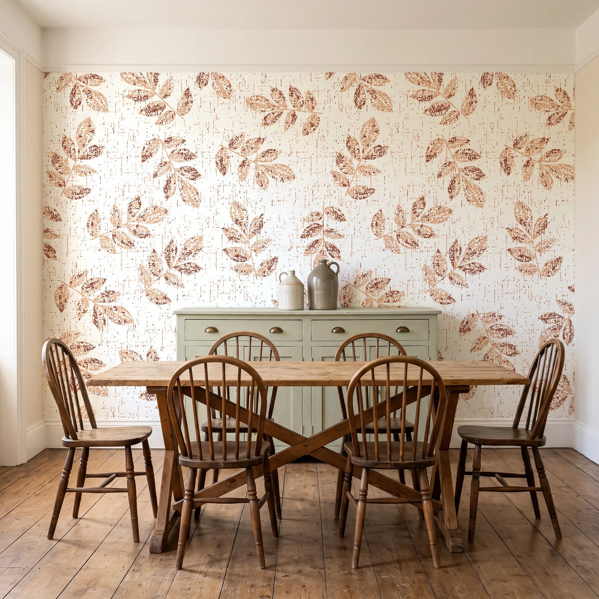 Verdant Scatter Terracotta tossed leaf wallpaper in a farmhouse dining room with a sage sideboard and rustic trestle table