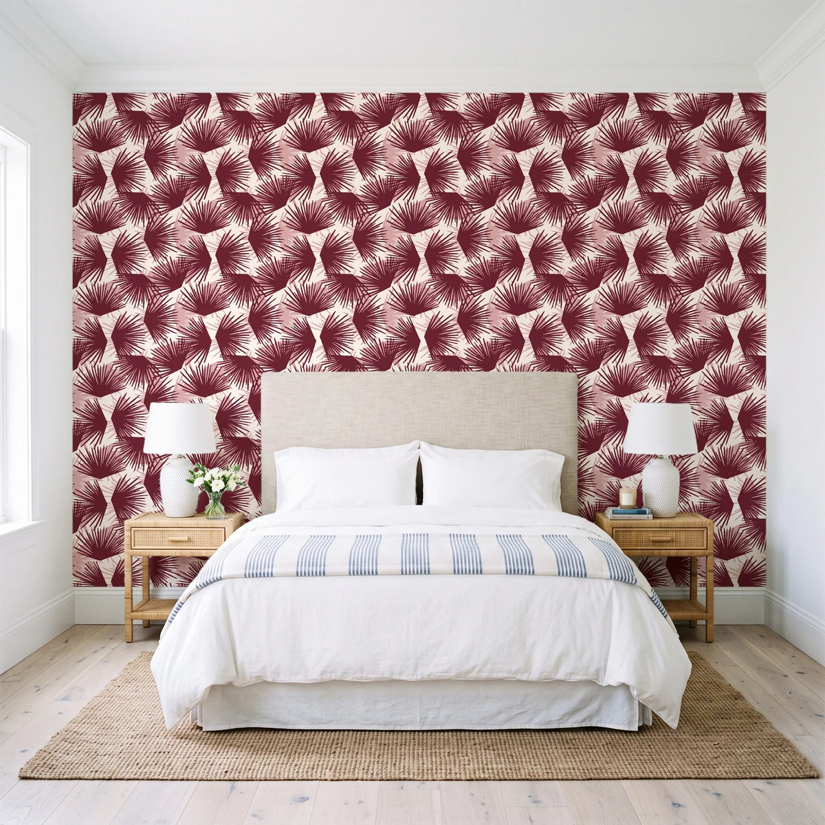 Wild Palm Oxblood palm wallpaper behind a queen bed in a bright coastal bedroom