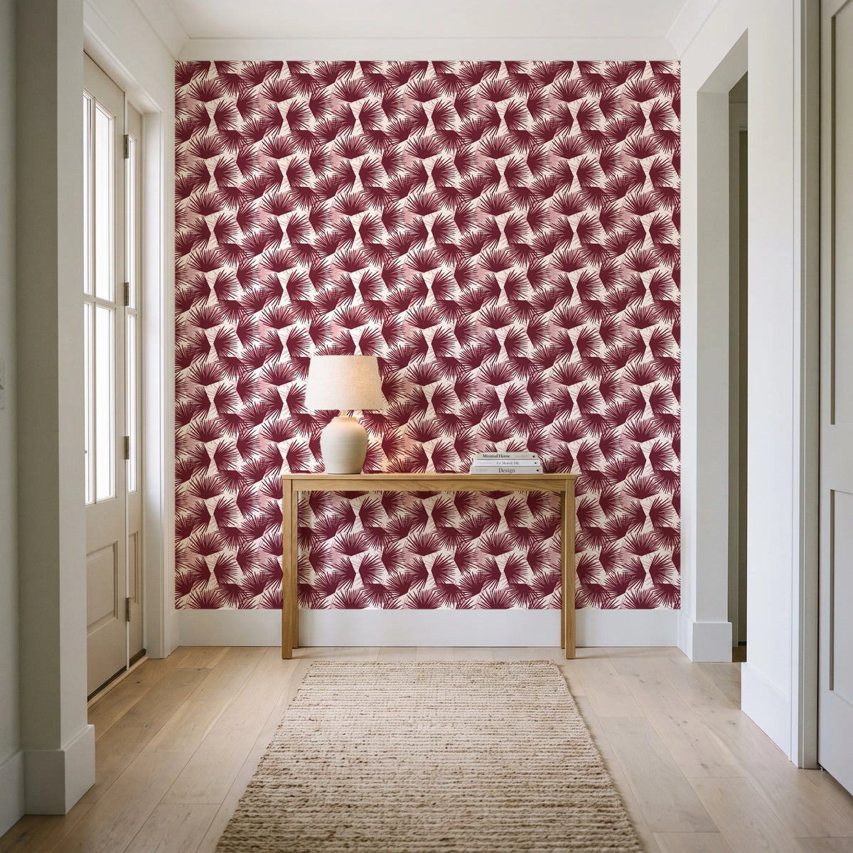 Wild Palm Oxblood palm wallpaper behind a console table in a light entry hallway