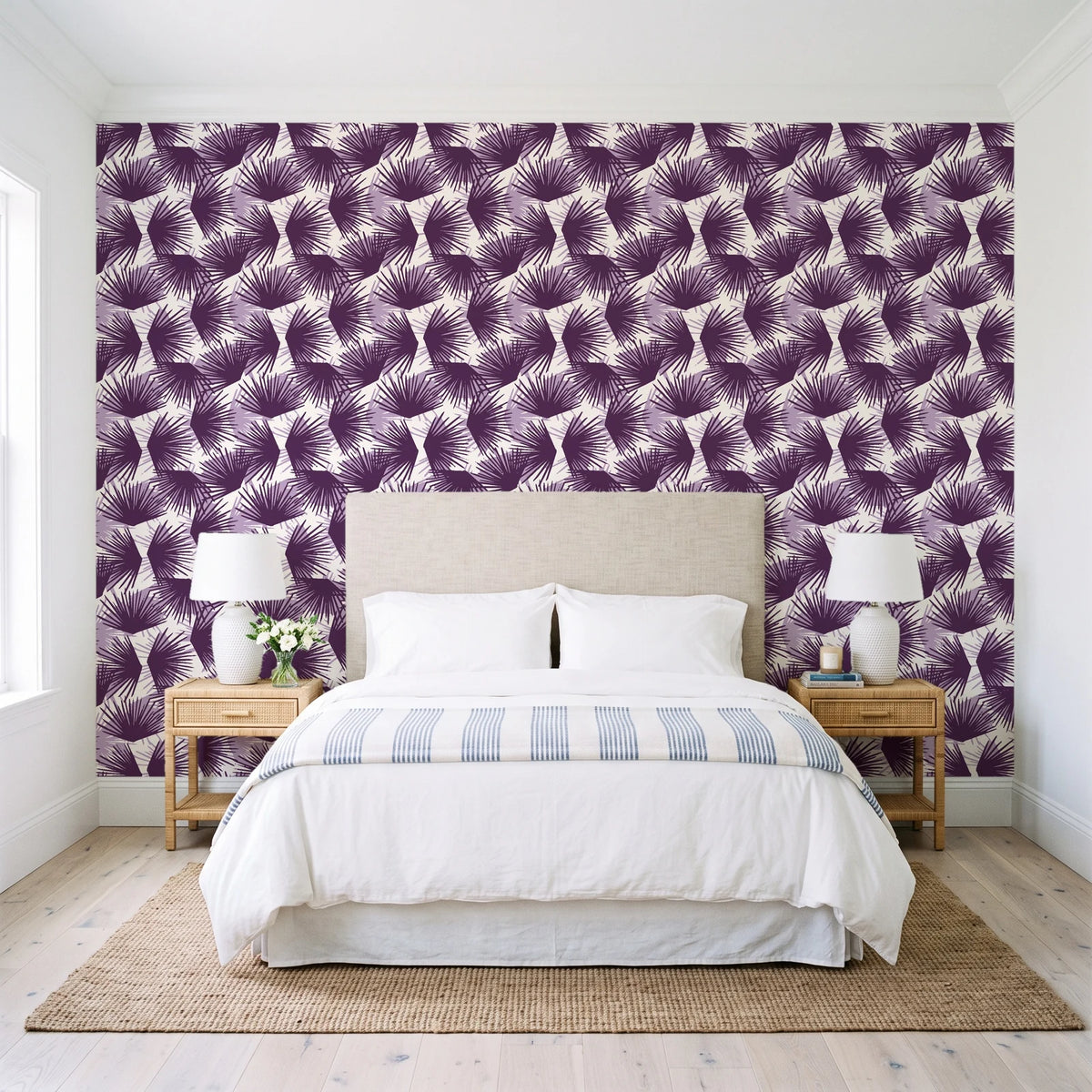 Wild Palm Plum palm wallpaper behind a queen bed in a bright coastal bedroom