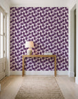 Wild Palm Plum palm wallpaper behind a console table in a light entry hallway