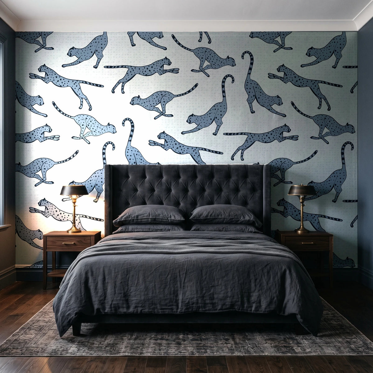 Wild Stride Slate cheetah wallpaper behind a tufted headboard in a dark, moody bedroom