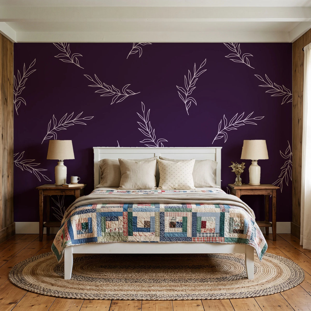 Willow Whisper Aubergine willow sprig wallpaper behind a white cottage bed with a patchwork quilt in a cozy cottagecore bedroom