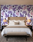 Winter Forage Plum pine bough and berry wallpaper behind the headboard of a king bed in a contemporary hotel guest room