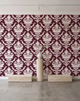 Woodland Blossom Veil Oxblood damask wallpaper behind a travertine pedestal and vase in a minimal boutique