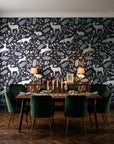 Woodland Hush Charcoal woodland animal wallpaper in a dark moody dining room with a candlelit table
