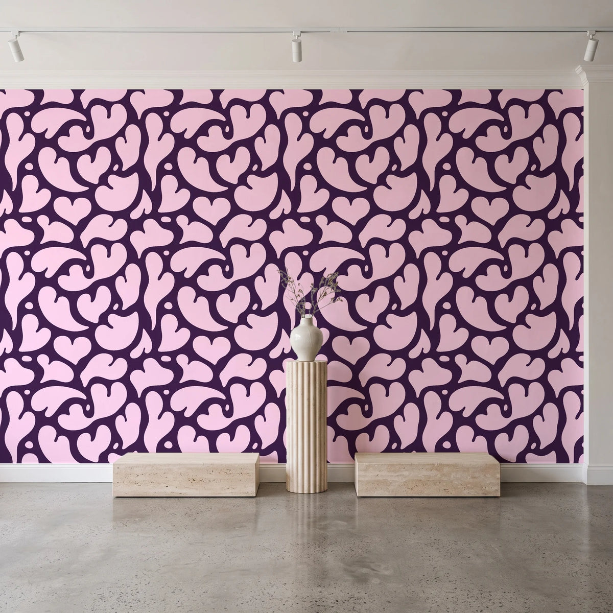 Woven Whisper Aubergine abstract heart wallpaper behind a travertine pedestal and vase in a minimal boutique