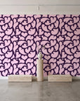 Woven Whisper Aubergine abstract heart wallpaper behind a travertine pedestal and vase in a minimal boutique
