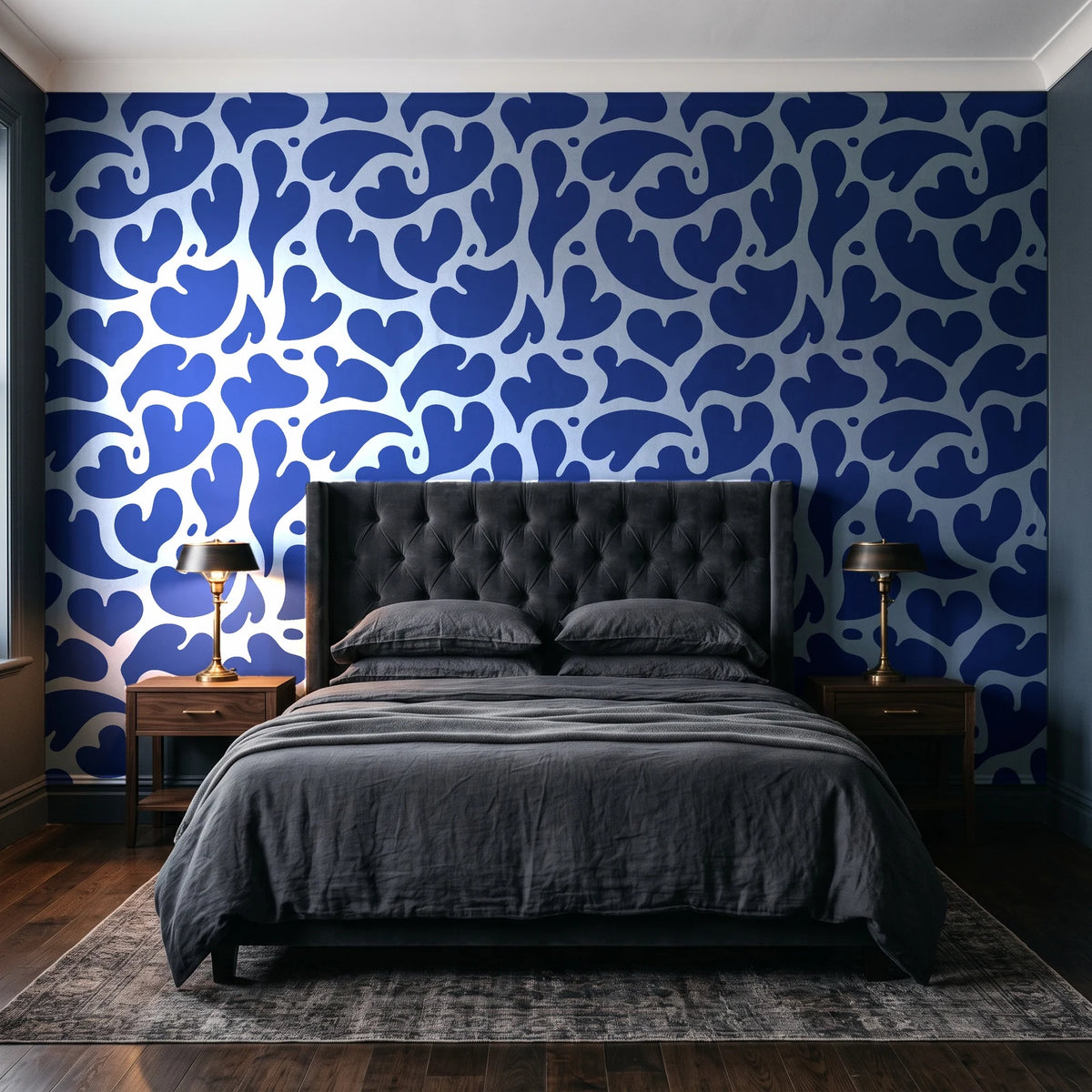 Woven Whisper Cobalt abstract heart wallpaper behind a tufted headboard in a dark, moody bedroom