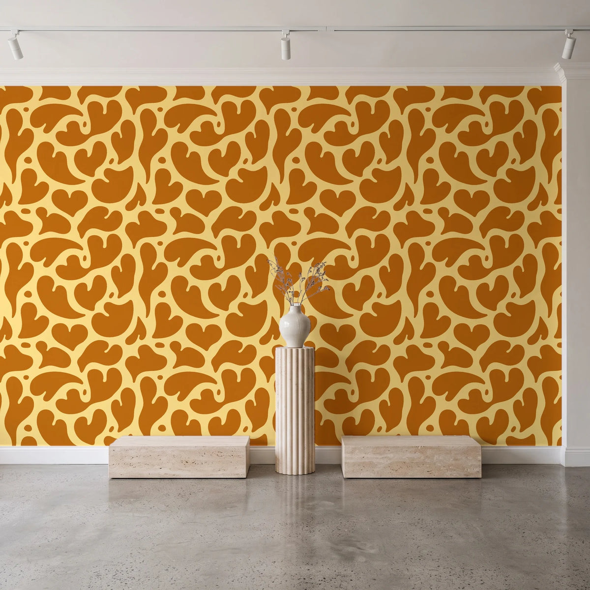 Woven Whisper Marigold abstract heart wallpaper behind a travertine pedestal and vase in a minimal boutique